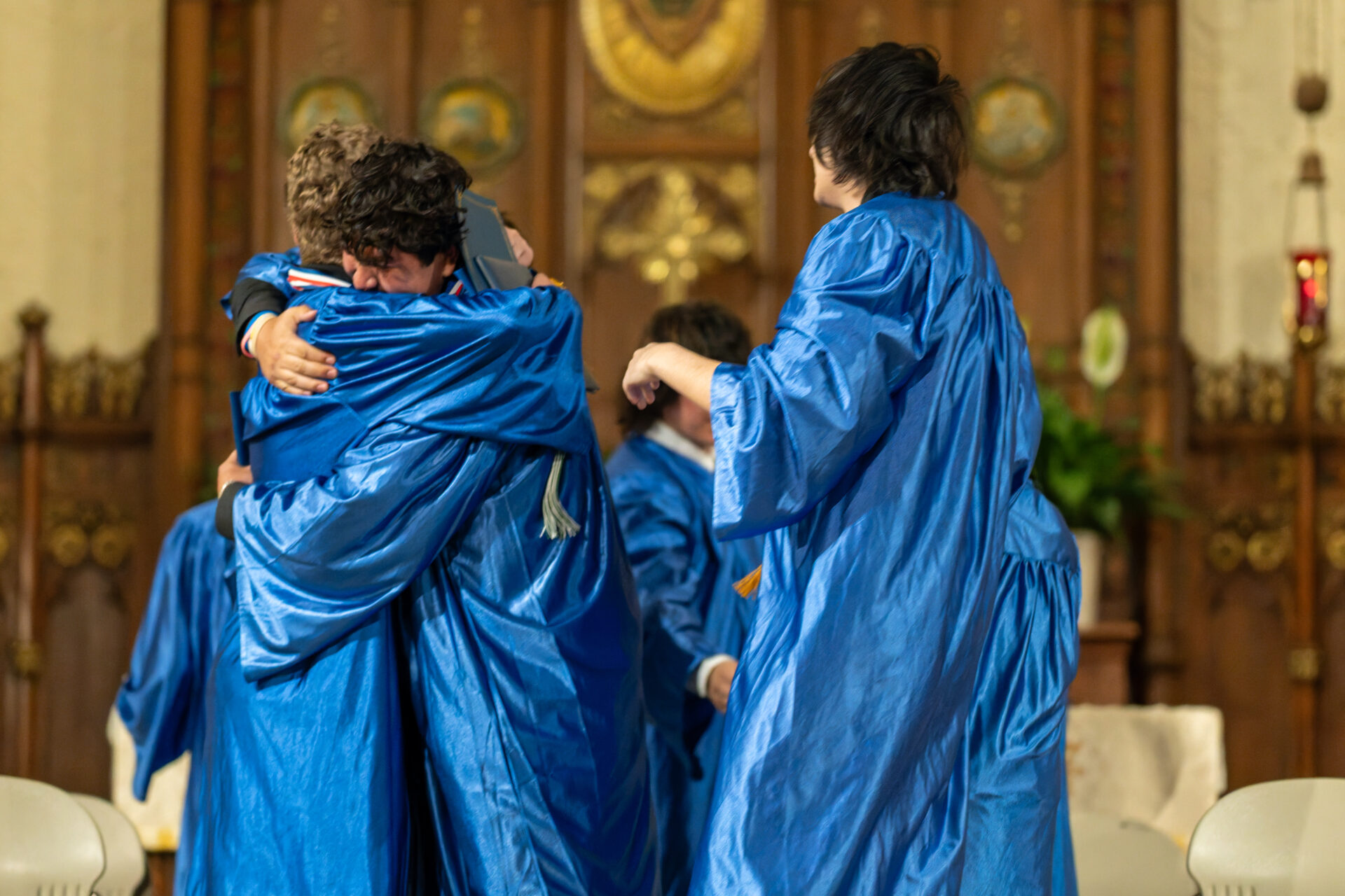 students hug at archway graduation